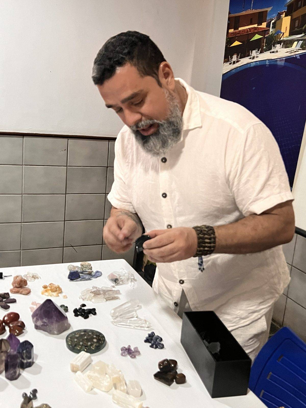 Remo preparando cristales sobre una mesa para la clase de cristaloterapia