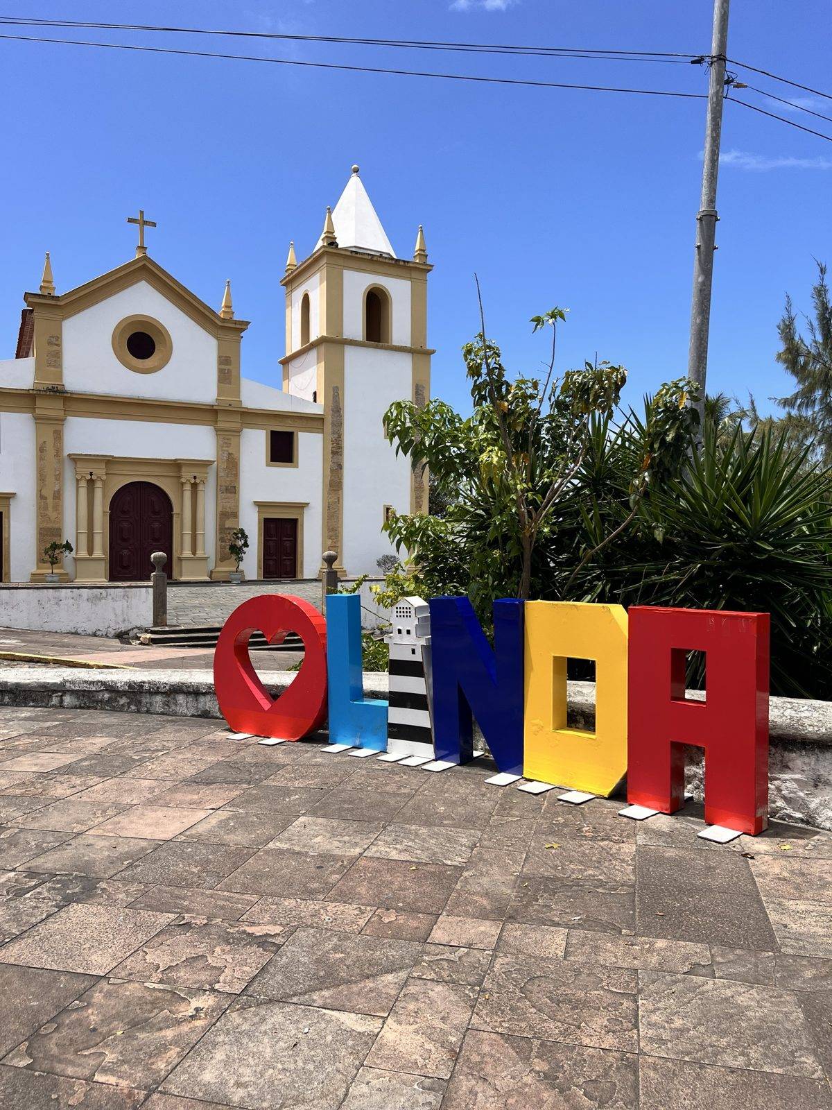 Letras de colores de Olinda frente a una iglesia colonial en Pernambuco, Brasil